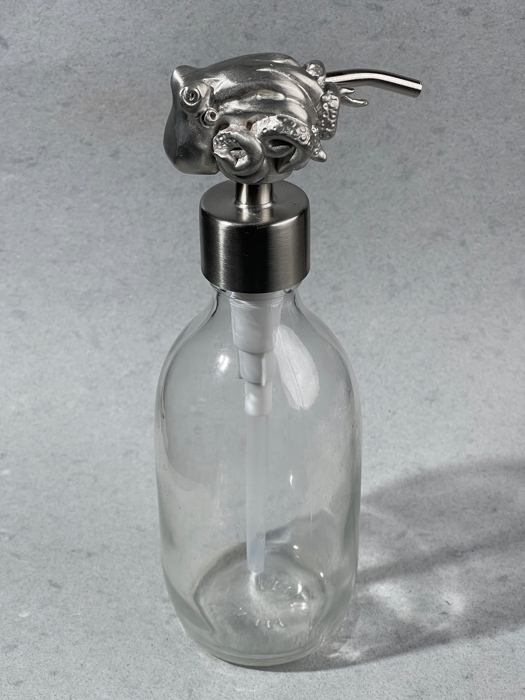 octopus sculptural soap pump on an empty bottle