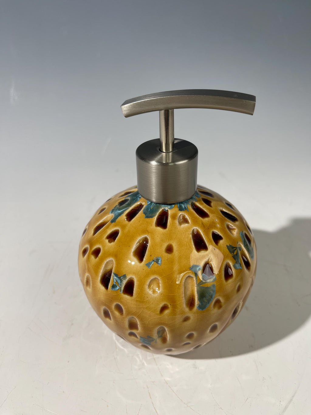 Soap and lotion pump sculptural crystalline golden  metropolis high rise window.
