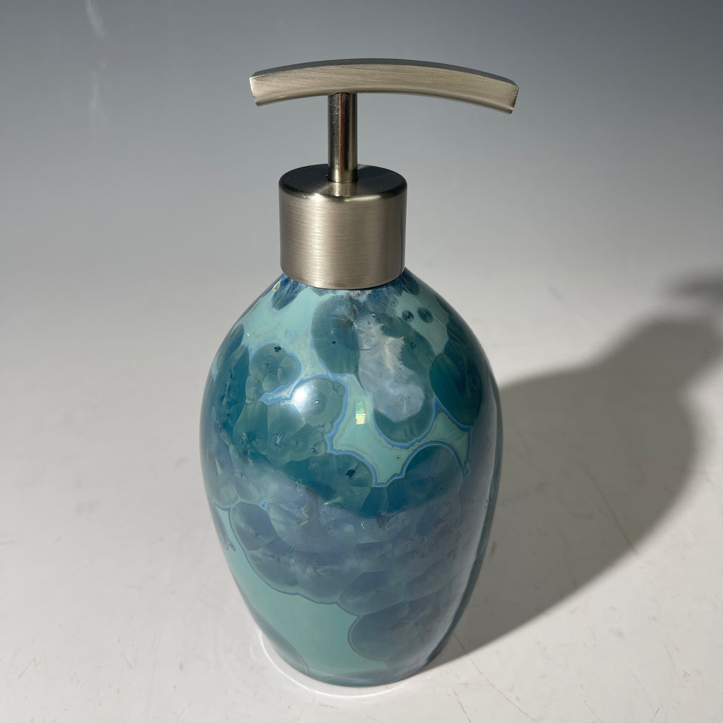 close up of a unique art soap dispenser by Hong Rubinstein in an ocean hued sparkling refractive  macro crystalline glaze