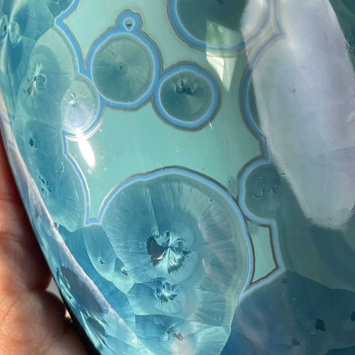 close up of a unique art soap dispenser by Hong Rubinstein in an ocean hued sparkling refractive  macro crystalline glaze