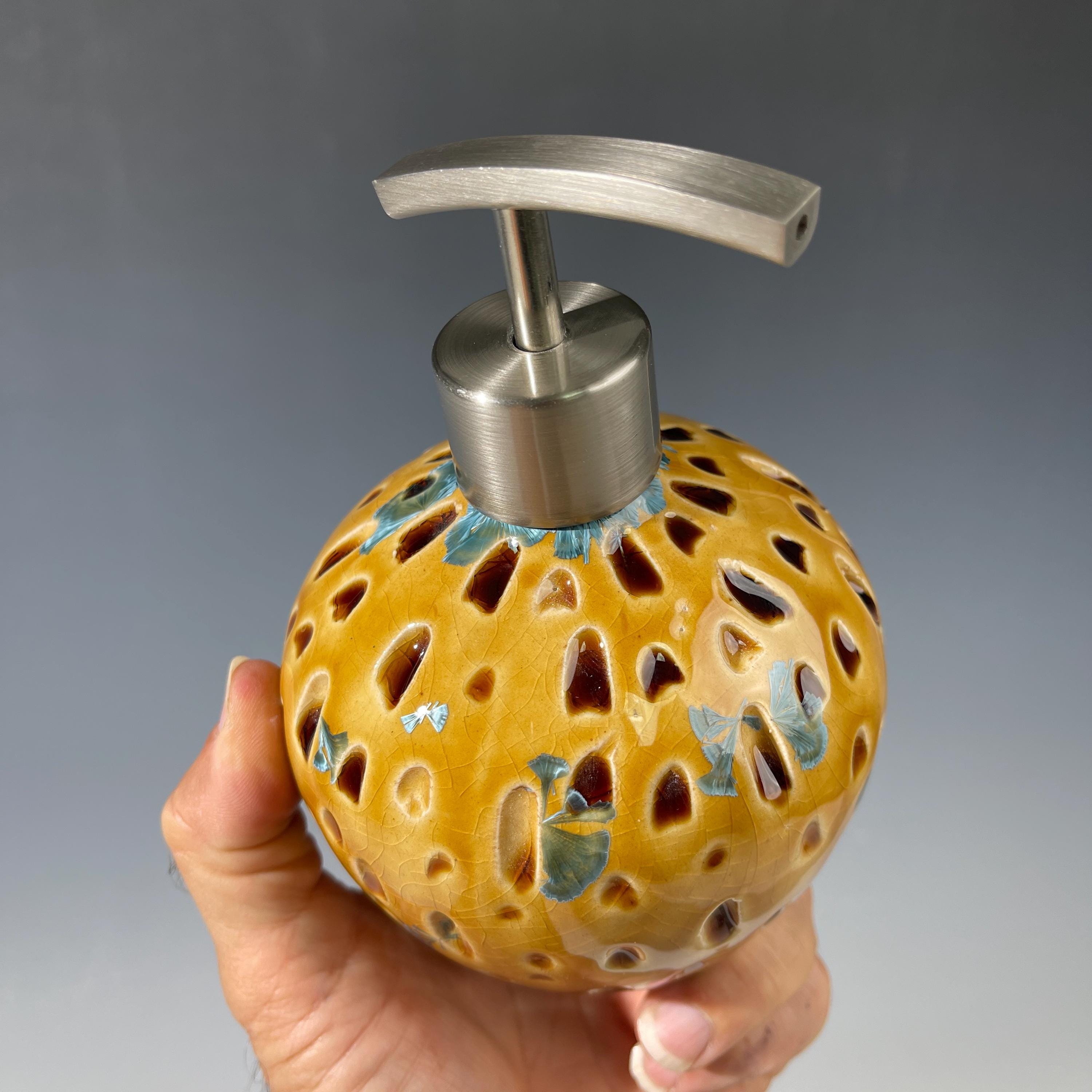 Soap and lotion pump sculptural crystalline golden  metropolis high rise window.