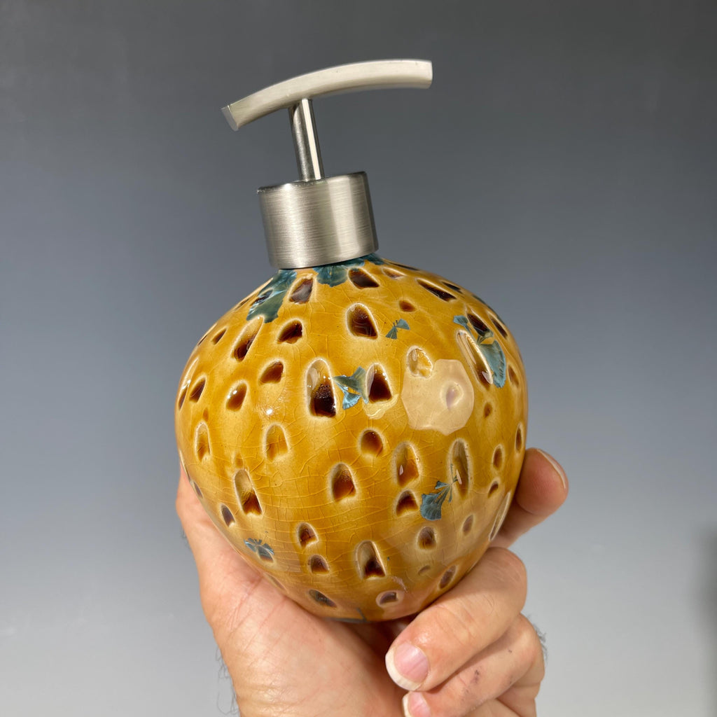 Soap and lotion pump sculptural crystalline golden  metropolis high rise window.