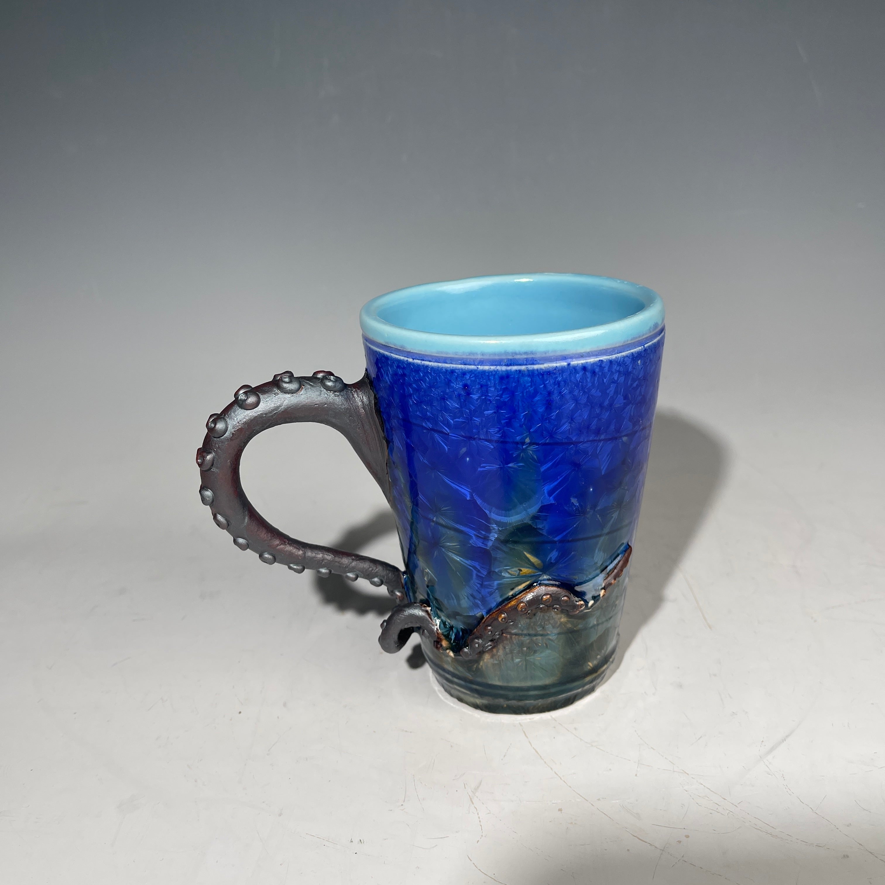 Octopus tentacled mug in deep ocean blue with sparkling crystals by Hong & Adam Rubinstein