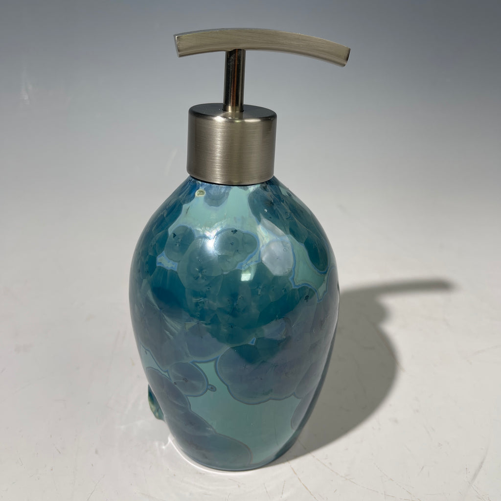 close up of a unique art soap dispenser by Hong Rubinstein in an ocean hued sparkling refractive  macro crystalline glaze