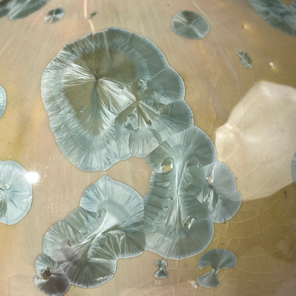  close up of the glaze of a handmade soap dispenser with amazing crystalline formations in the glaze in green hues