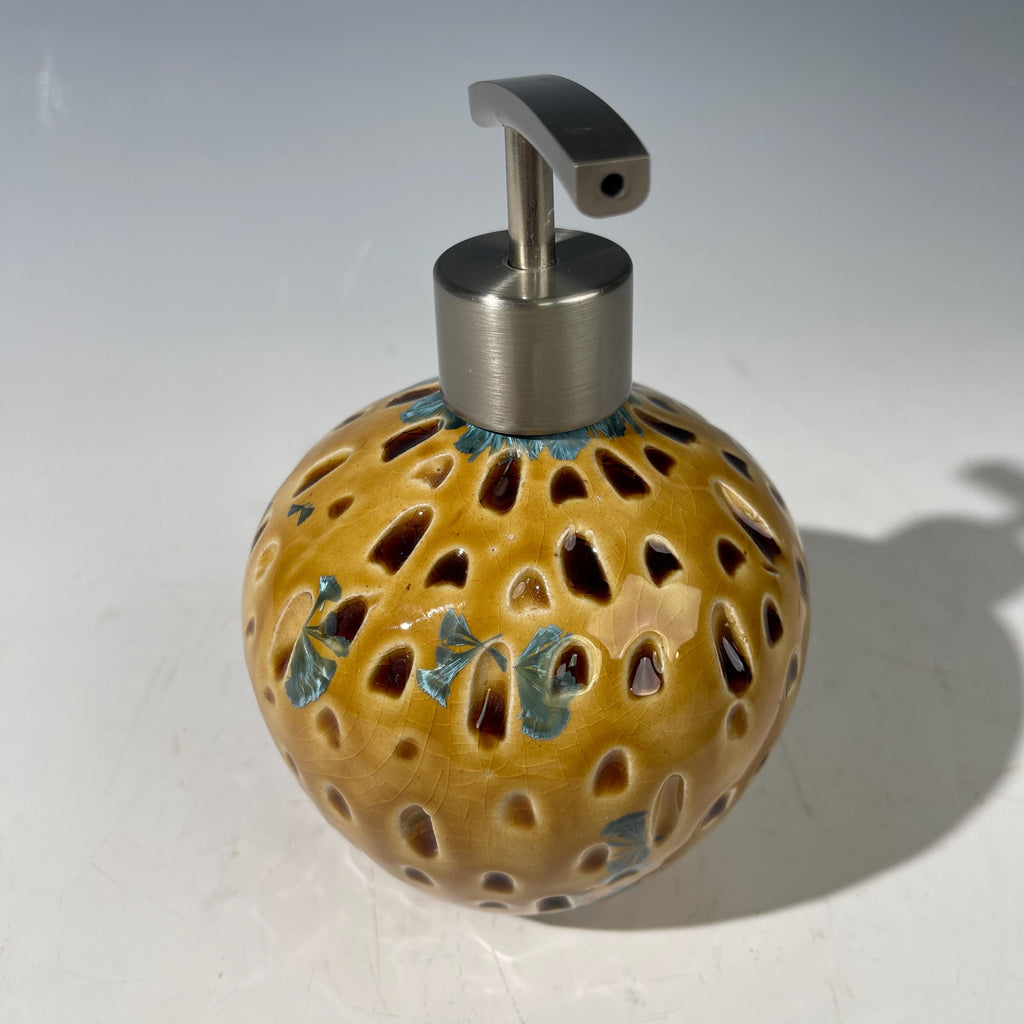 Soap and lotion pump sculptural crystalline golden  metropolis high rise window.