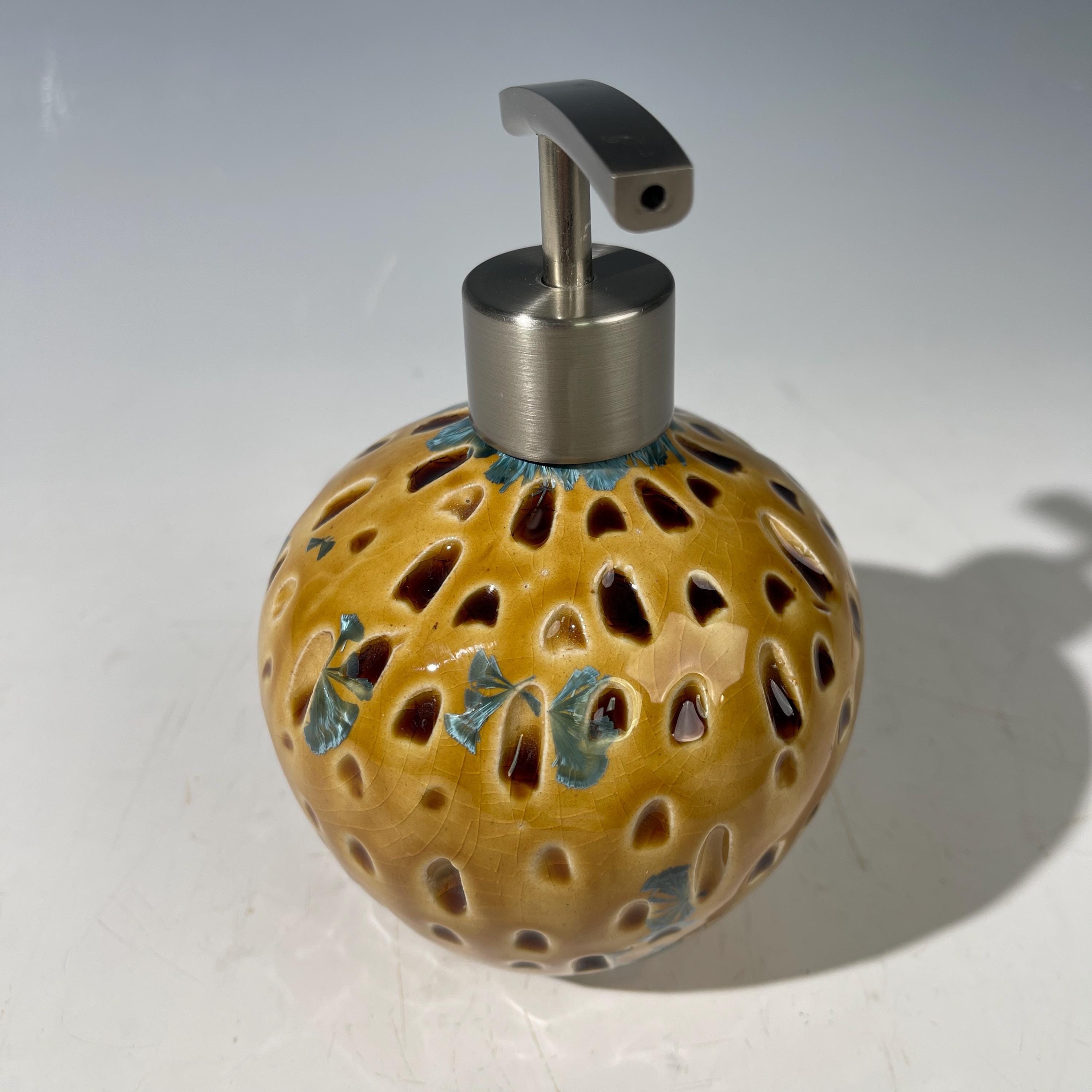 Soap and lotion pump sculptural crystalline golden  metropolis high rise window.