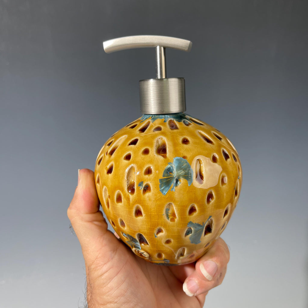Soap and lotion pump sculptural crystalline golden  metropolis high rise window.